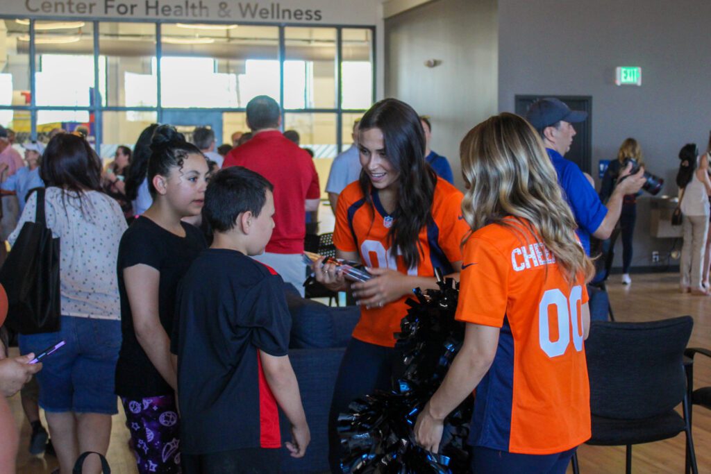 Guests talking to Denver Broncos cheerleaders at the Boys & Girls Clubs of Weld County's Teen Center grand opening event.