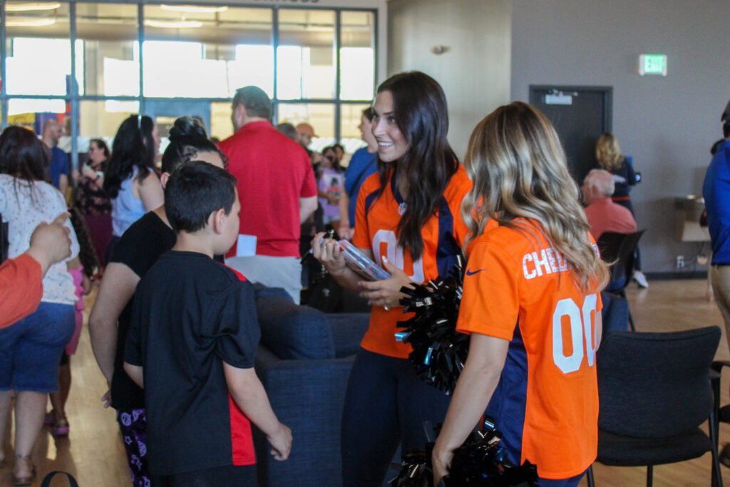 Guests talking to Denver Broncos cheerleaders at the Boys & Girls Clubs of Weld County's Teen Center grand opening event.