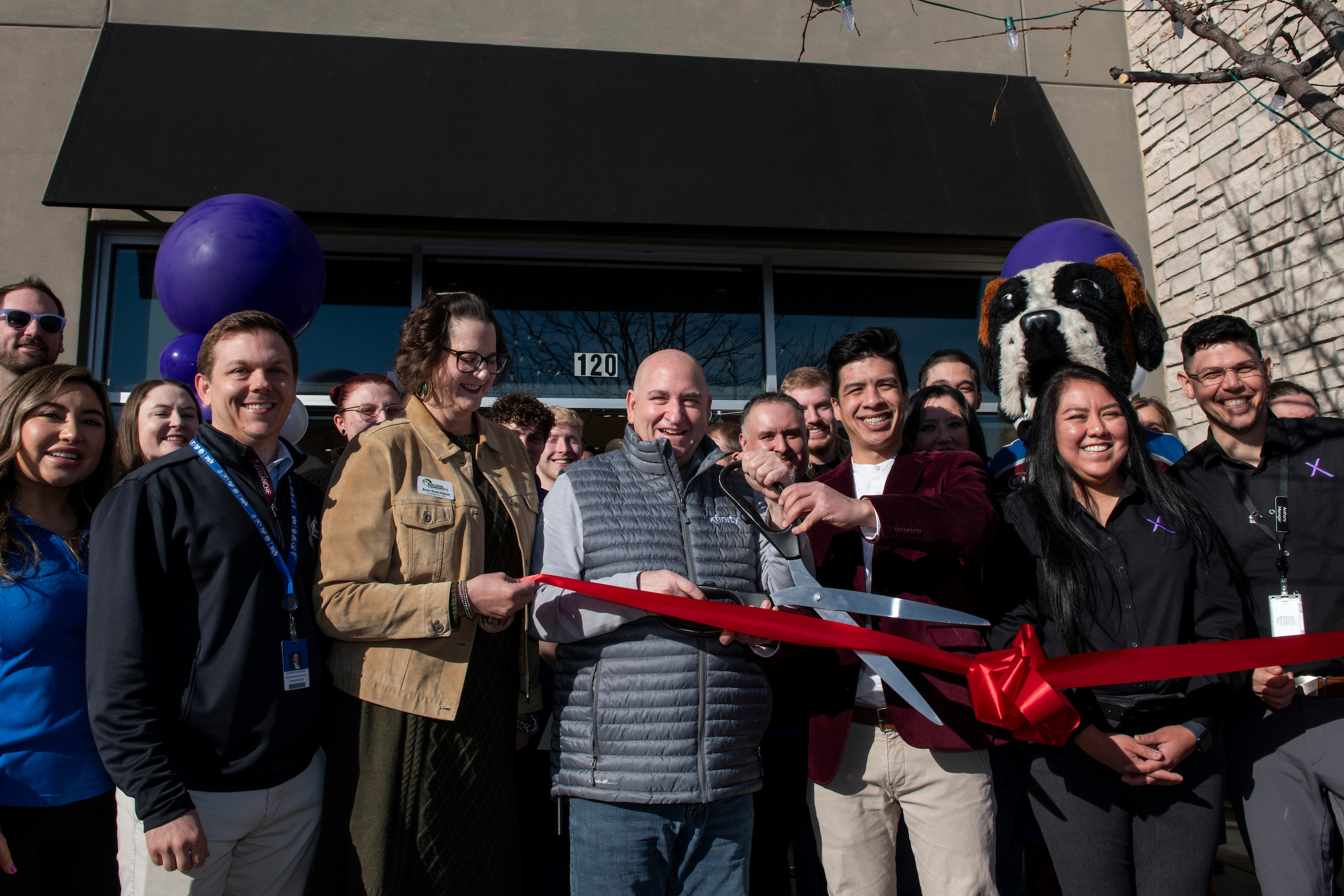 Comcast employees and city leaders cutting a ribbon outside the new Xfinity Store in Fort Collins.