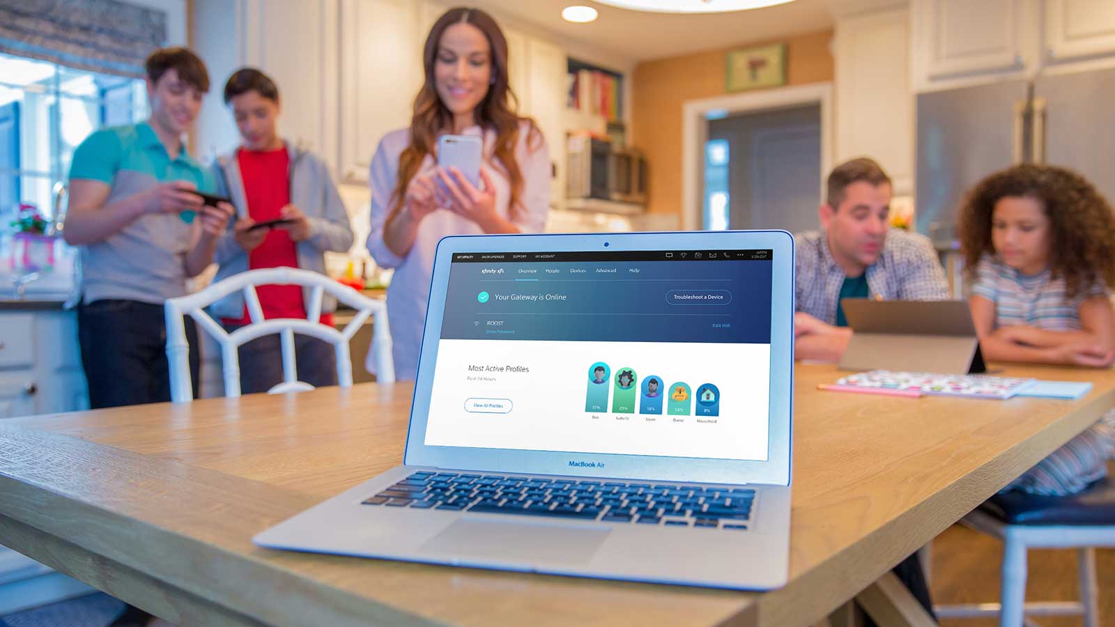 Family in kitchen using wireless devices