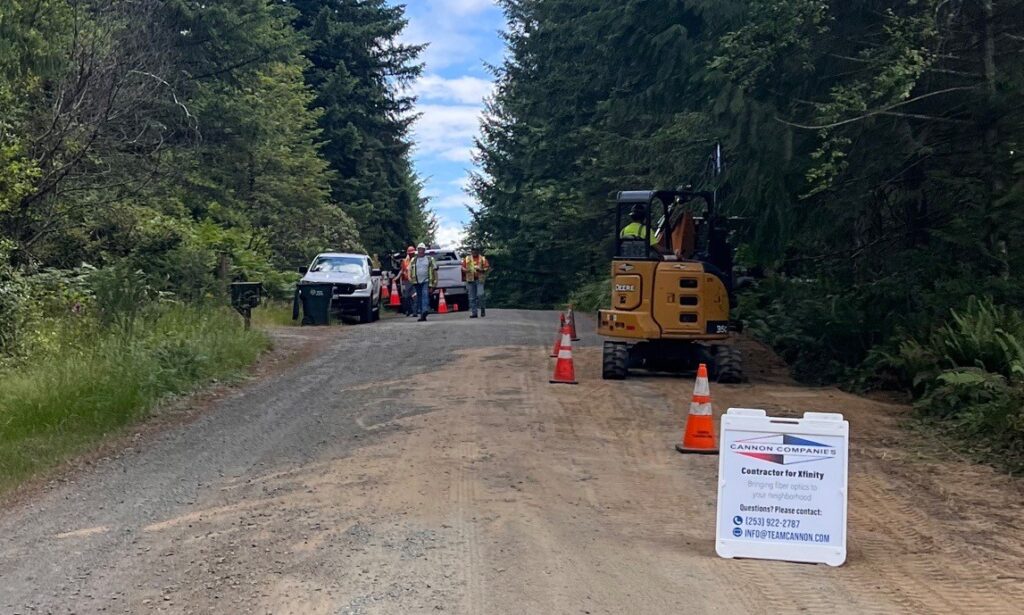 Machinery with trucks and workers work on a road. 