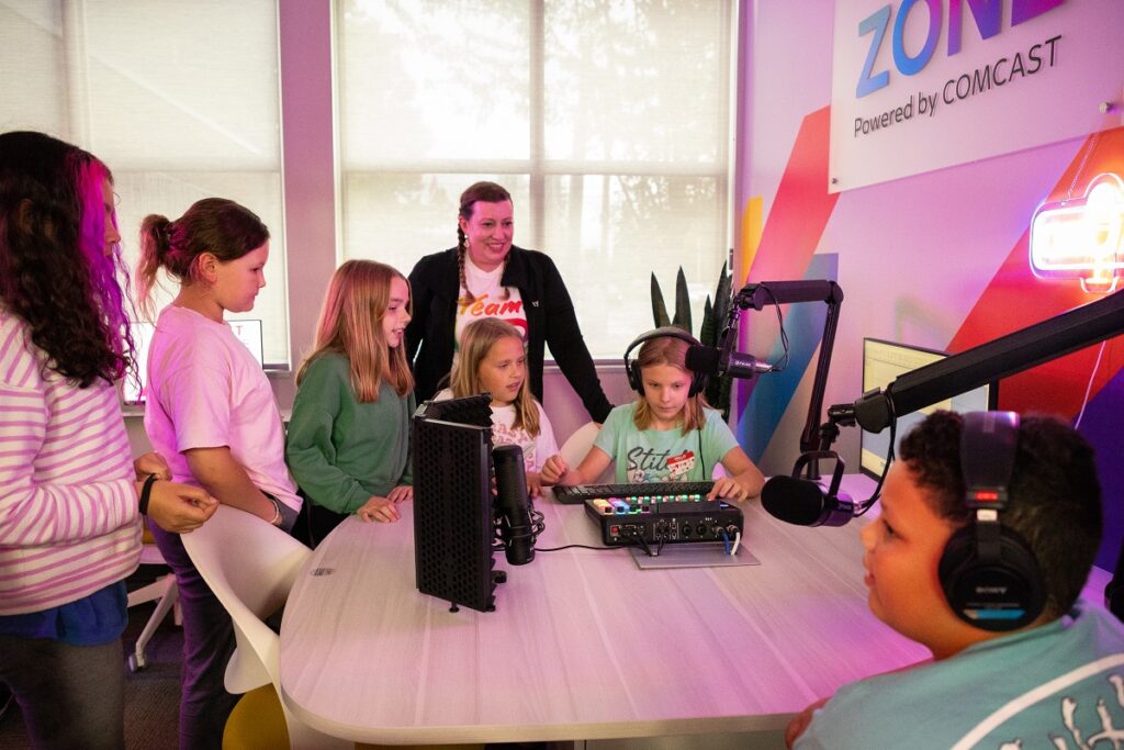 Children from the Boys & Girls Club of Snohomish with a Comcast volunteer in the podcast studio. 