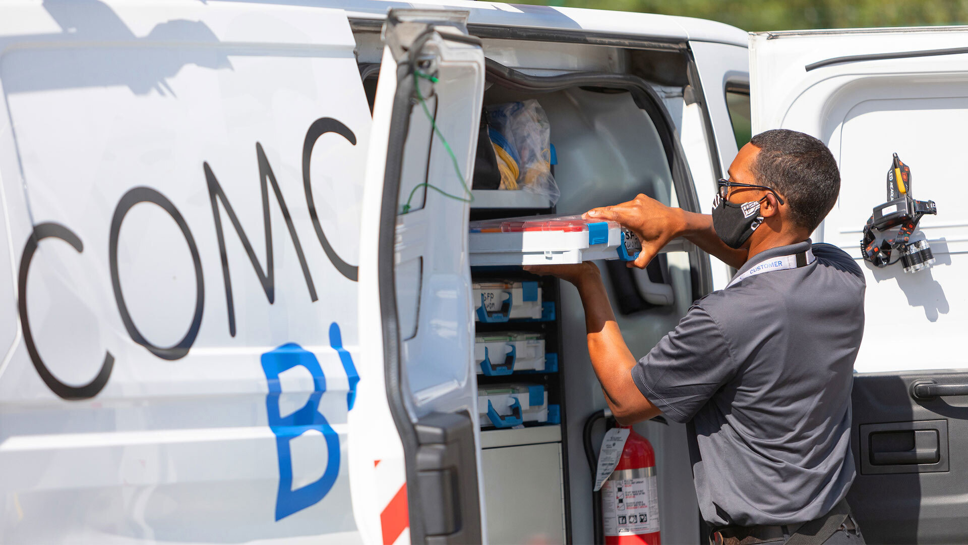A Comcast technician unloads supplies from a van