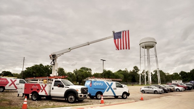 Xfinity trucks pared with one flying an American flag from it's crane