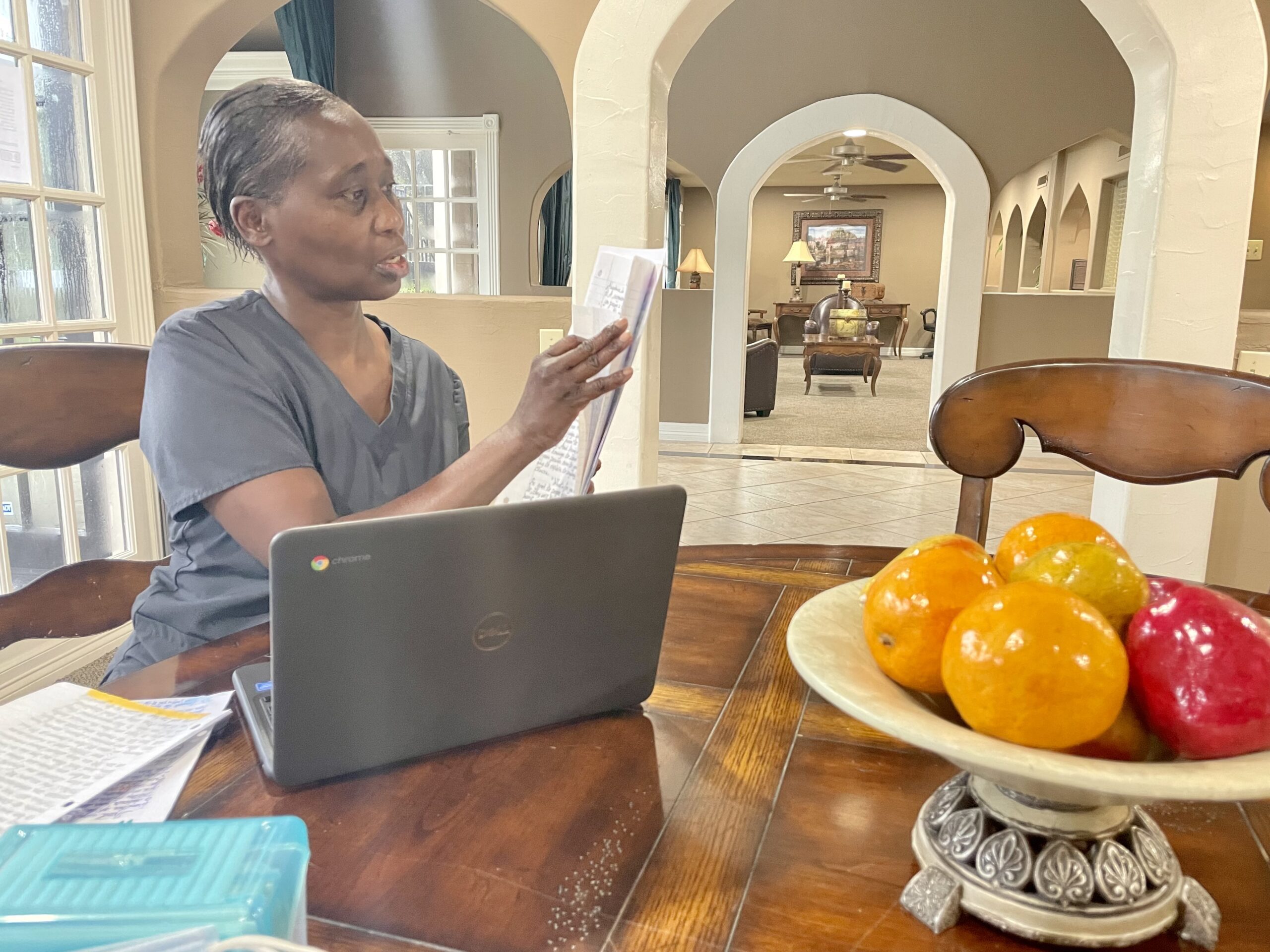 Cheryl Cook seated at table with laptop opened