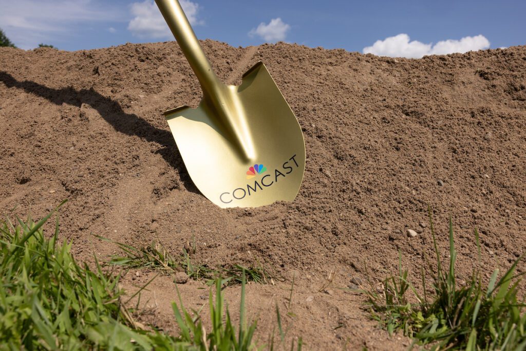 Gold Comcast Shovel in the dirt.