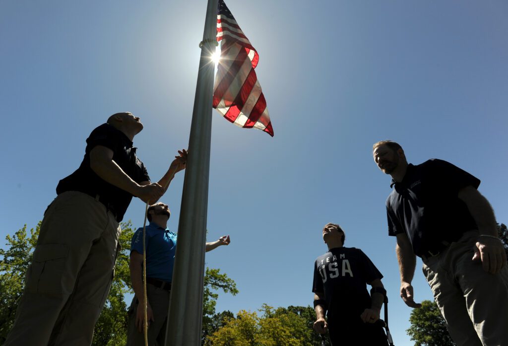 People raise an American flag. 