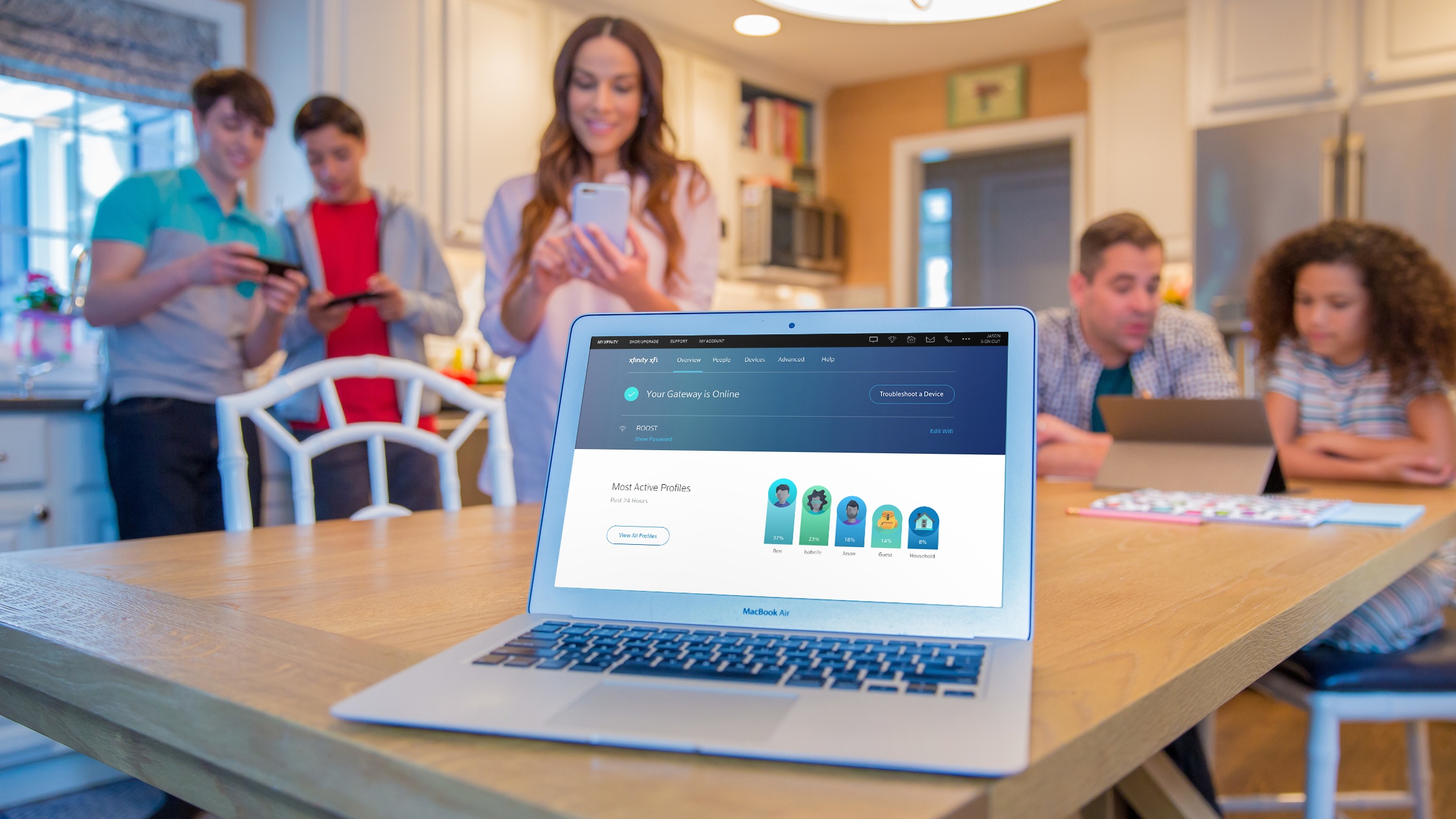 A family is gathered around a laptop displaying the status of their Xfinity xFi devices.