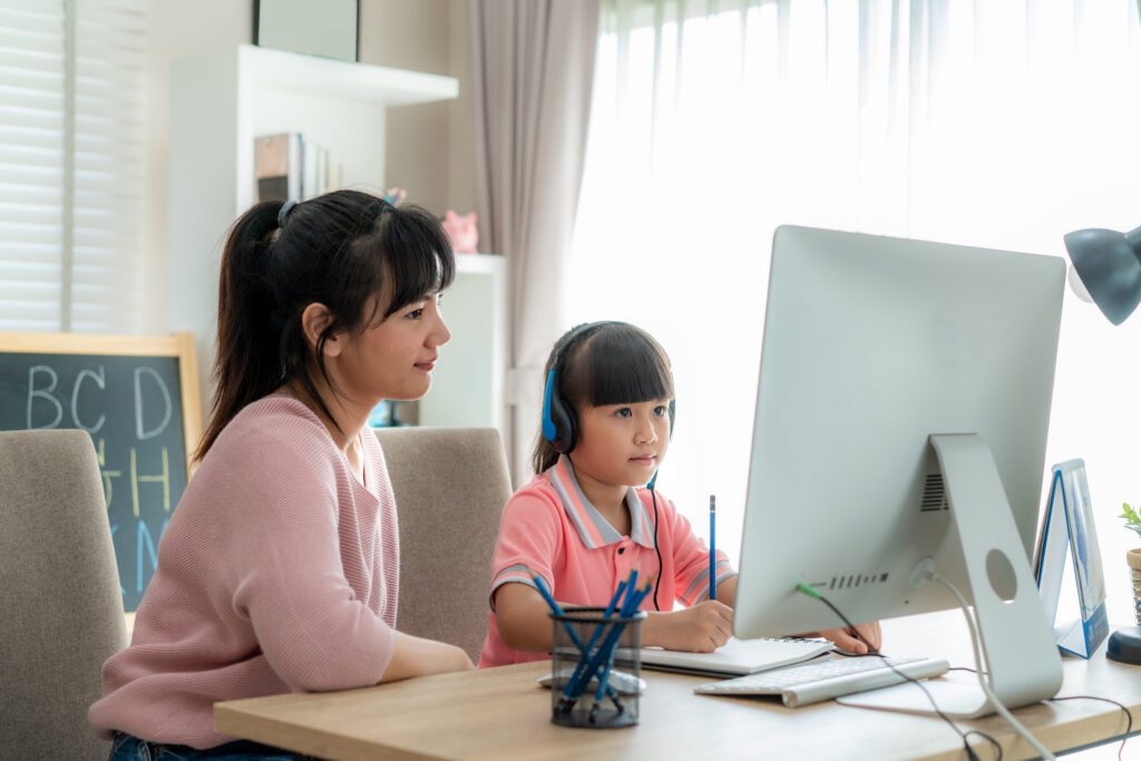 Mom with young student explore the world of e-learning for academic success and bridge the digital divide for National Online Learning Day