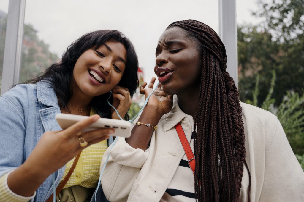 Students enjoying music from a cell phone from NOW Mobile, which offers low cost pre-paid plans.