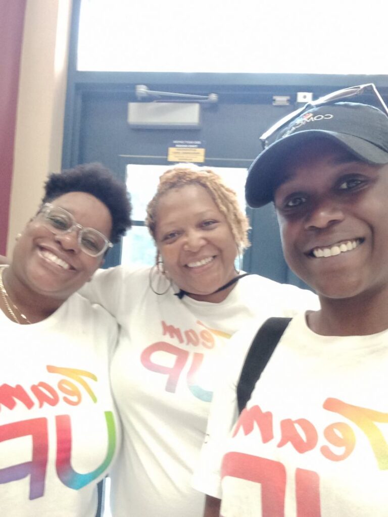 Three volunteers in Team UP t-shirts