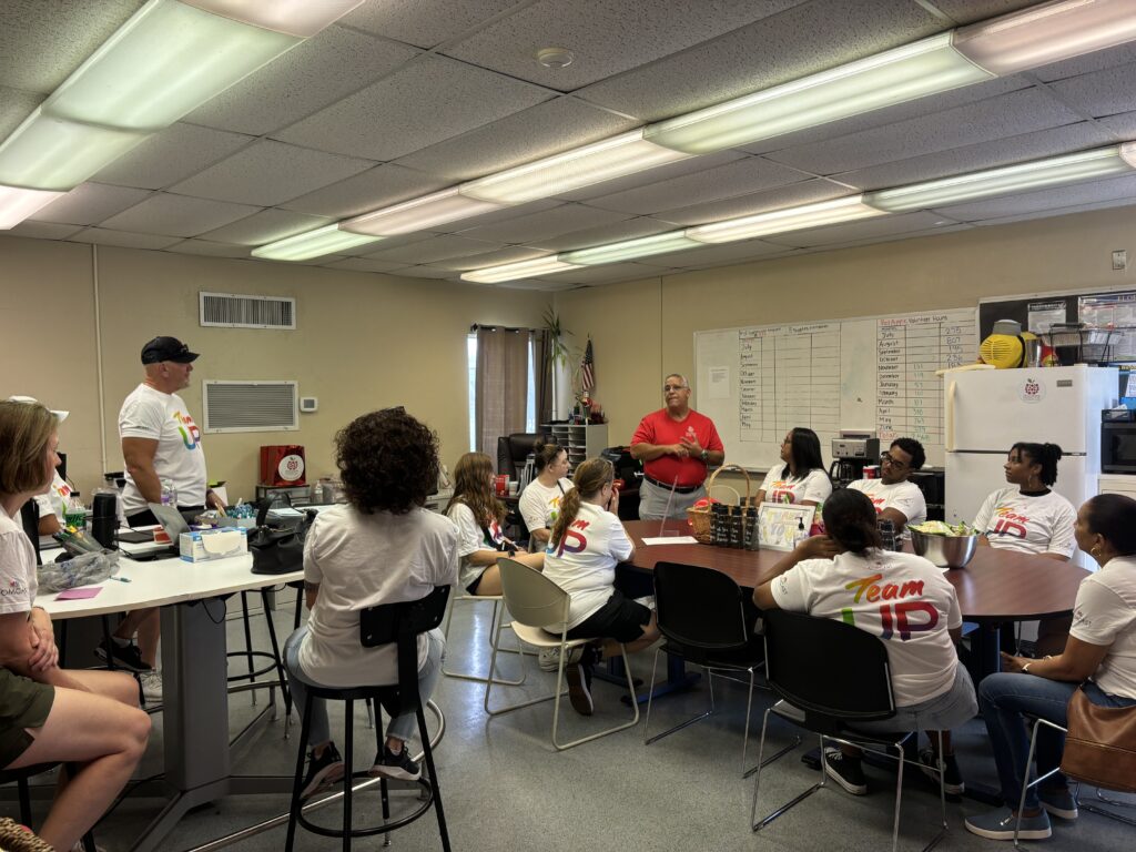 man gives a speech to volunteers in a room