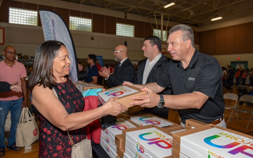 man hands out laptop to a woman