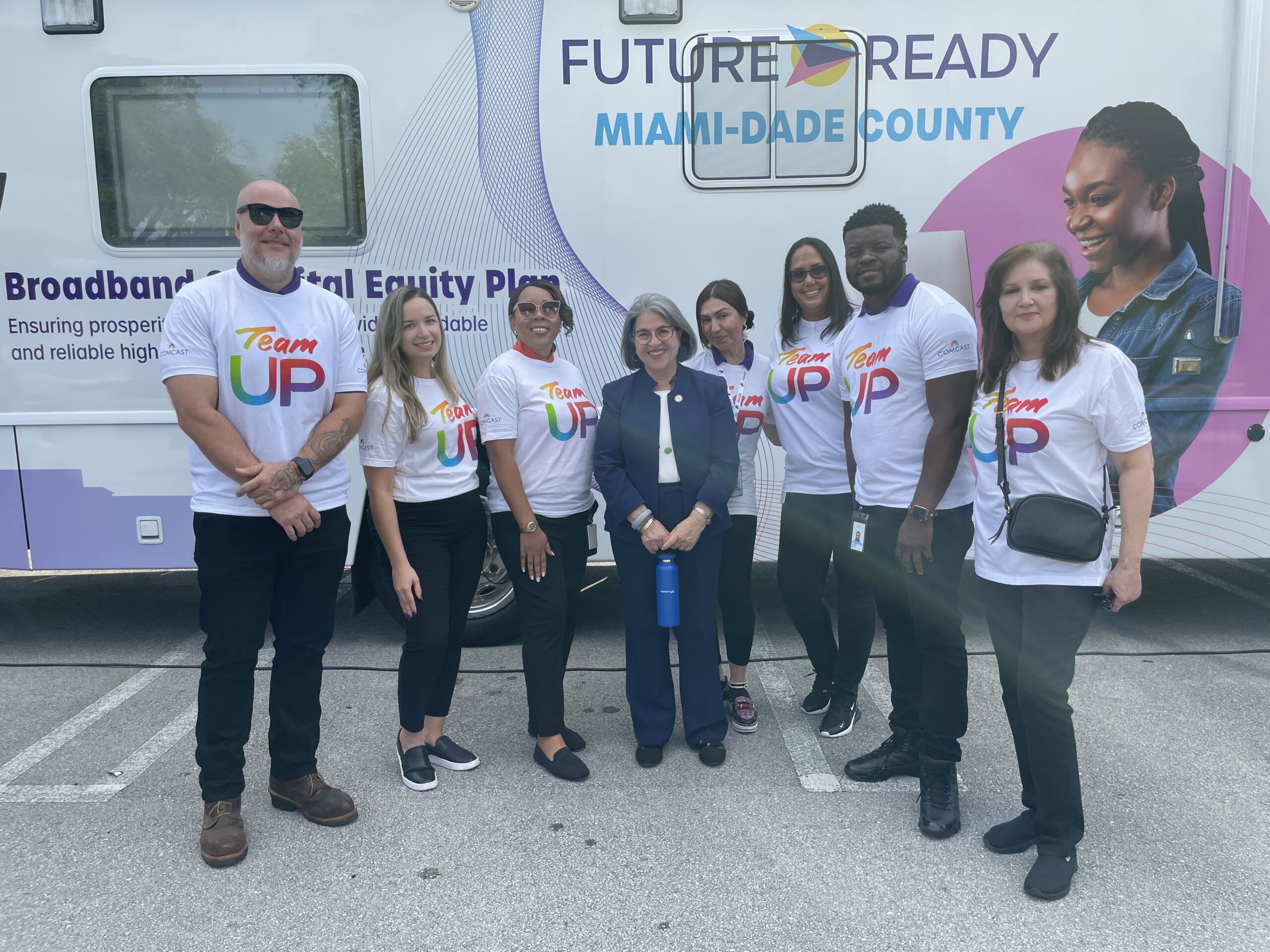 Group of peple posing in front of a bus