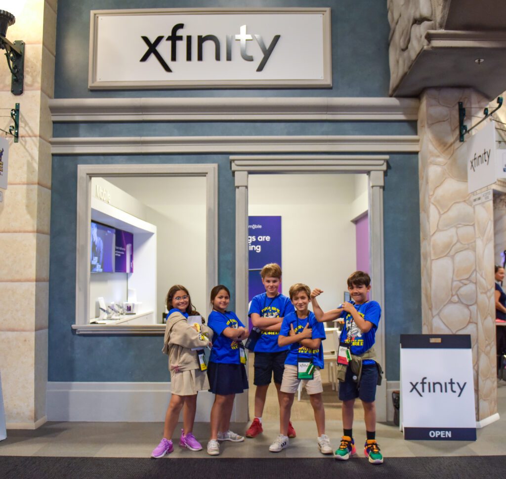 Students pose for a photo in front of the Xfinity store.