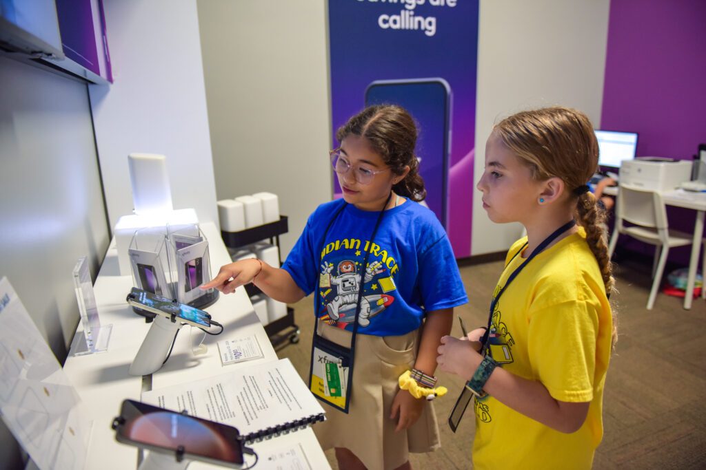 A student sells a smart phone in the Xfinity store at JA Biztown.