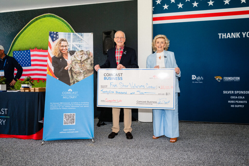 man and woman posing with a large check in hand