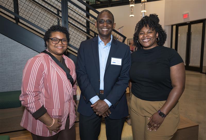 two women and a man pose for a picture