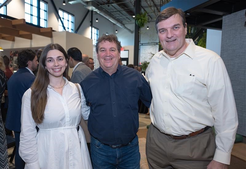 two men and one woman pose for a picture