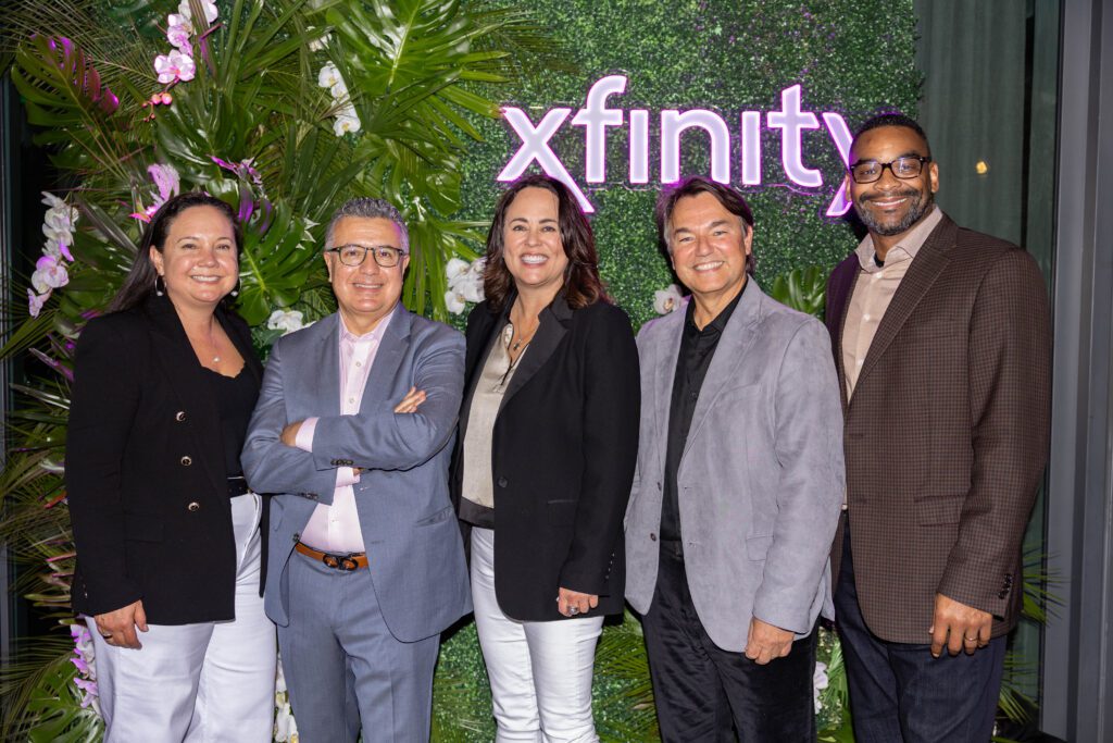 Five executives posing for a picture at an event