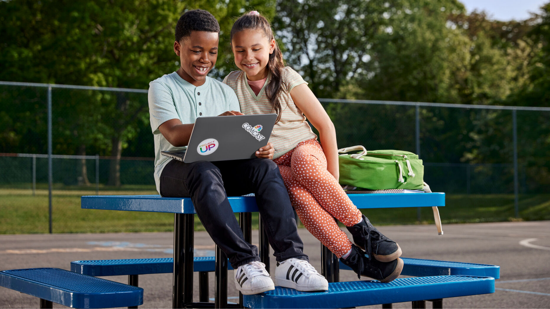 Kids in park on laptop