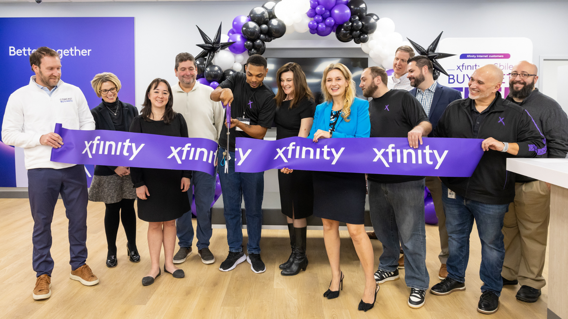 Group cutting the ribbon at Comcast's Springfield Xfinity Store.