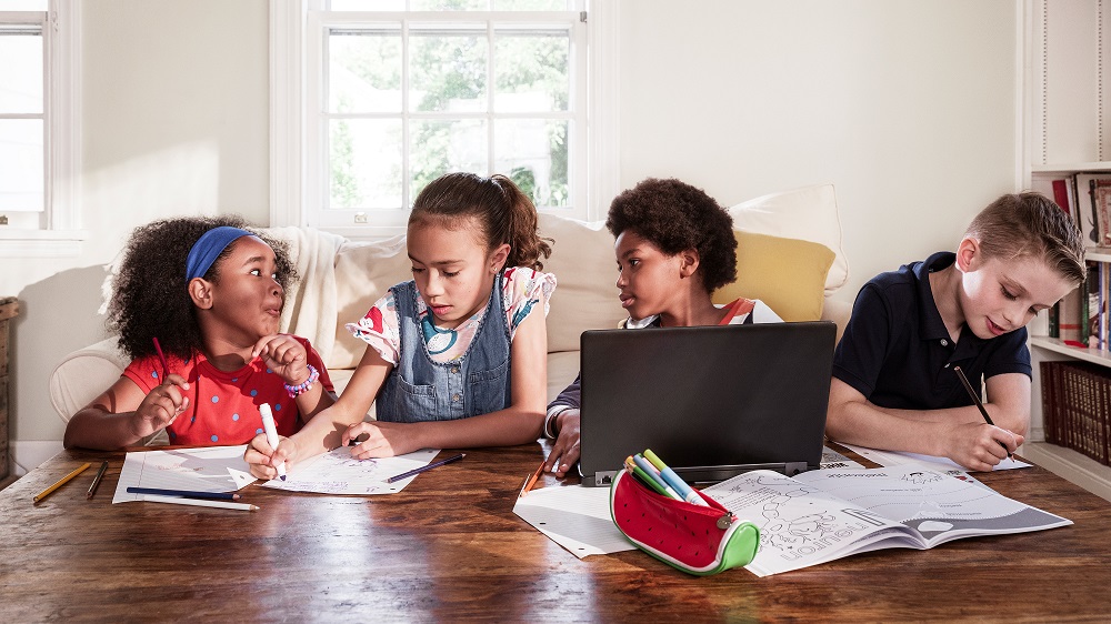 Children do homework together on a table.