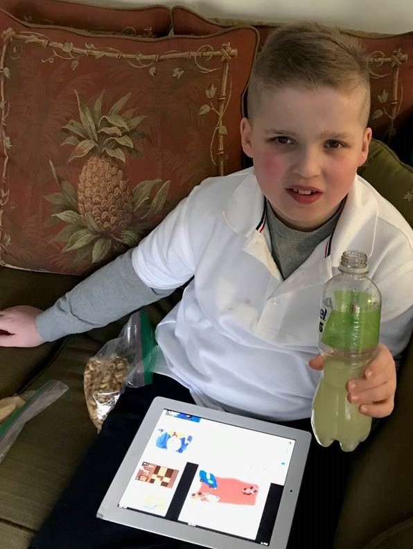 Caleb holding snacks with tablet on his lap.